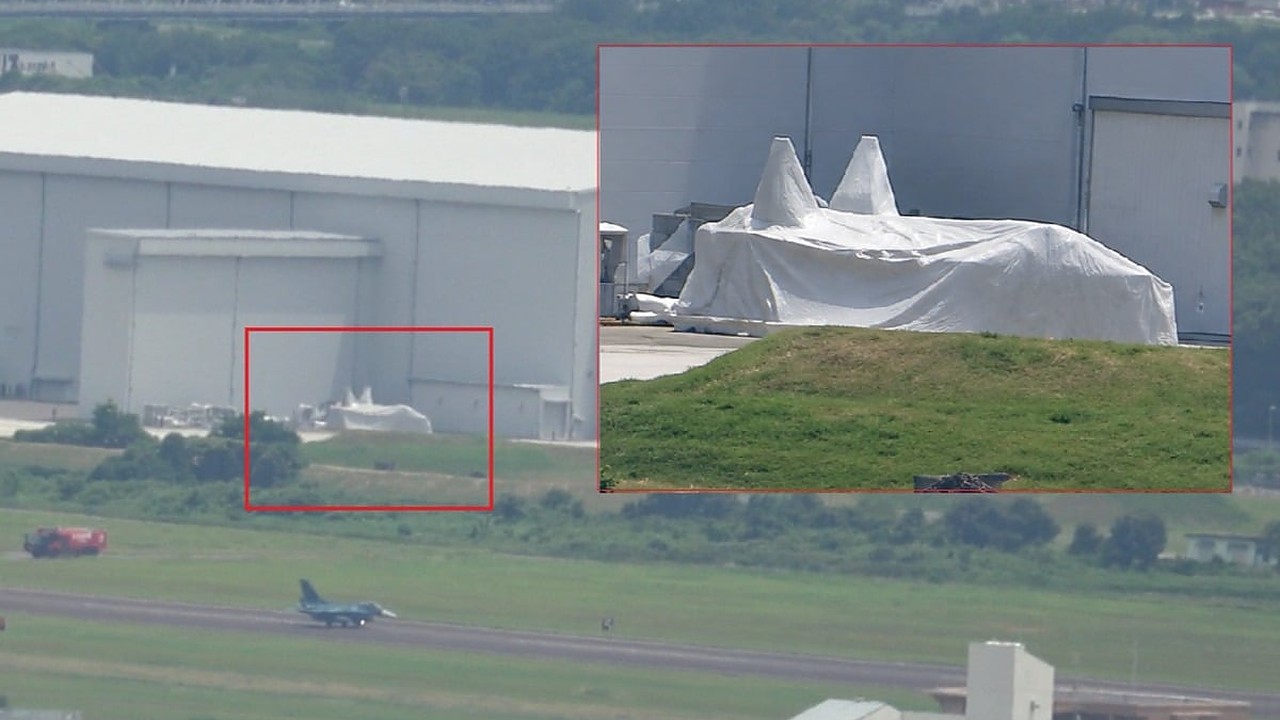 Avión bimotor cubierto de tela blanca fotografiado en la base aérea de Gifu, Japón.