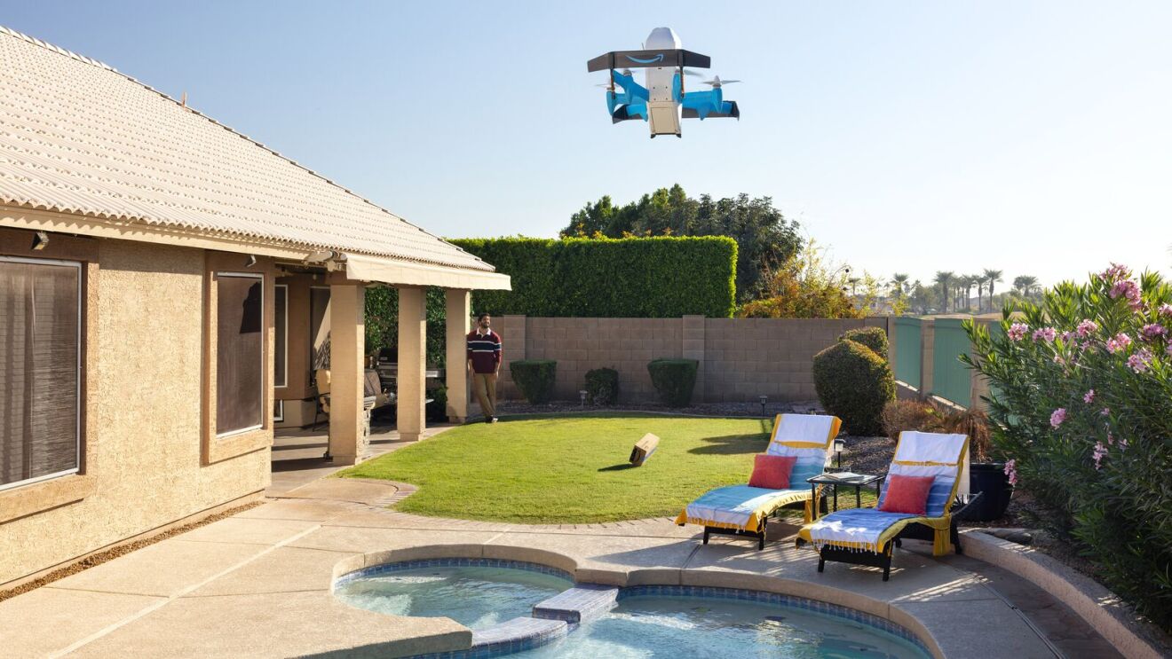 Un dron Amazon Prime Air MK30 descendiendo sobre el jardín trasero de una vivienda.