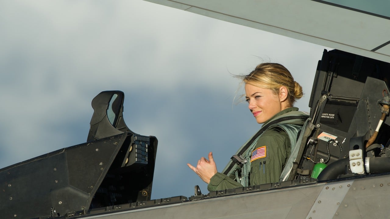 Emma Stone, as Captain Allison Ng, sits in the cockpit of an F-22 Raptor giving the shaka sign during filming of the movie Aloha