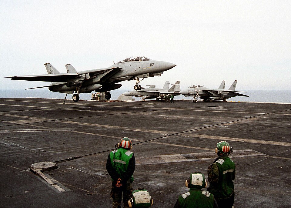 Un caccia F-14 Tomcat della Marina statunitense aggancia il cavo di arresto durante un atterraggio su una portaerei.