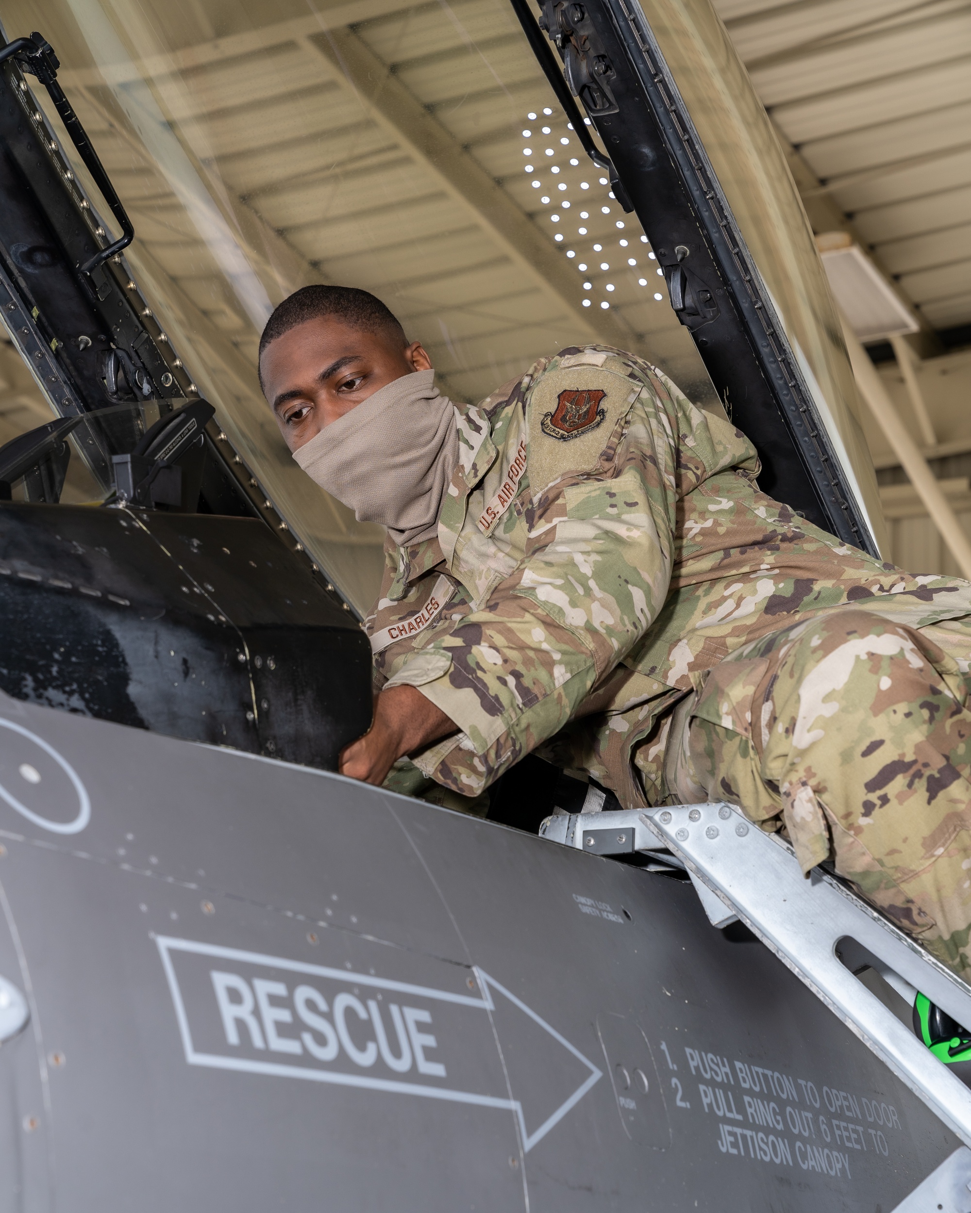 Ein Avioniktechniker inspiziert das Instrumentenbrett eines F-16-Cockpits.