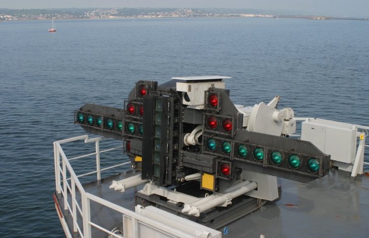 Sistema ottico di atterraggio con lente di Fresnel, noto come "meatball", che guida i piloti durante gli atterraggi sulle portaerei.