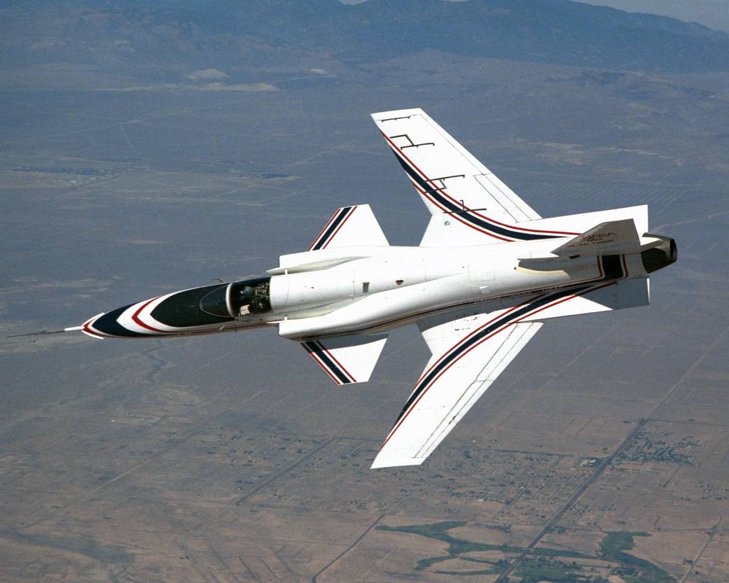 Grumman X-29 forward-swept-wing aircraft banking in flight over desert