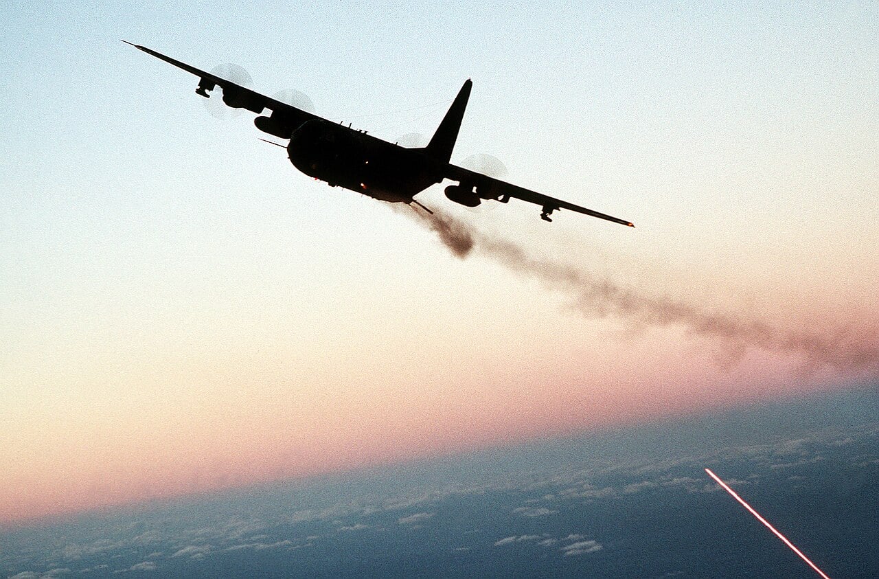 Un aereo da attacco AC-130 spara con le sue armi in bordata durante una missione notturna.