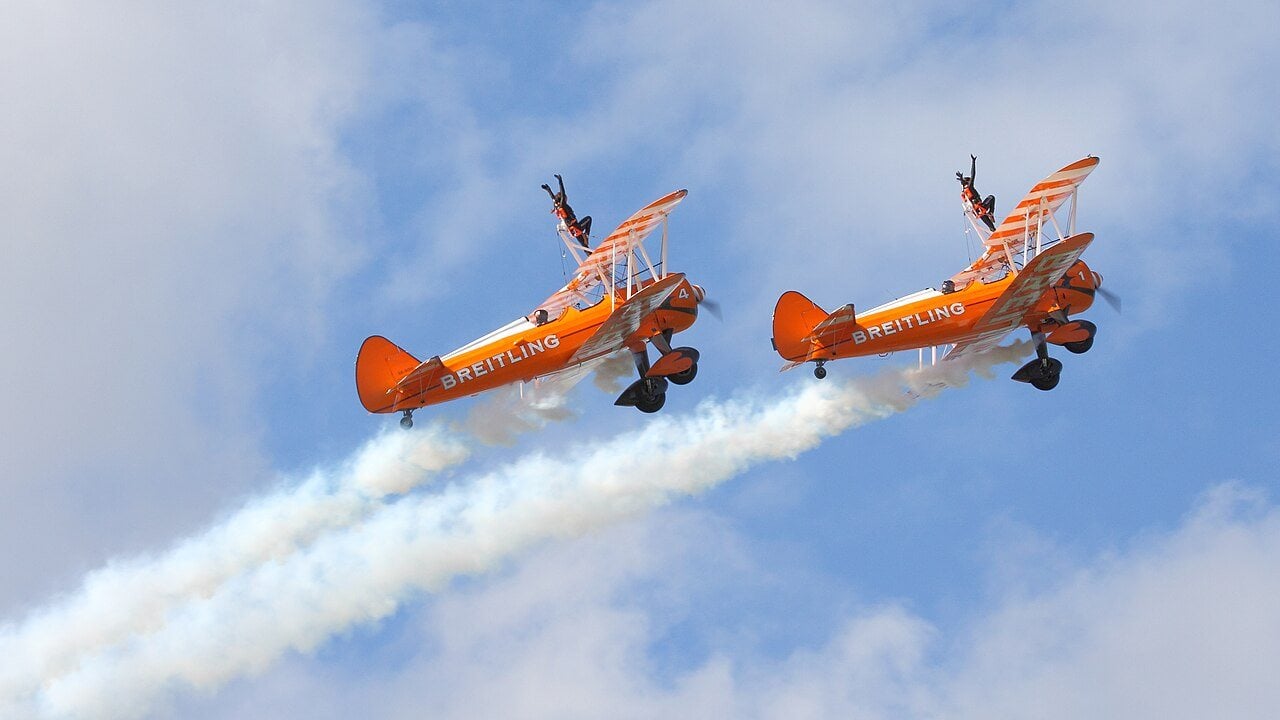 Les Breitling Wingwalkers se produisent sur des biplans Boeing Stearman orange