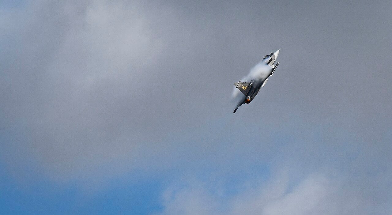 Swedish Air Force Saab JAS 39E Gripen climbing with wingtip vortices