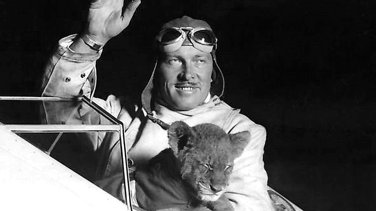 Roscoe Turner with Gilmore the lion cub Roscoe Turner waving from the cockpit while holding Gilmore the lion cub