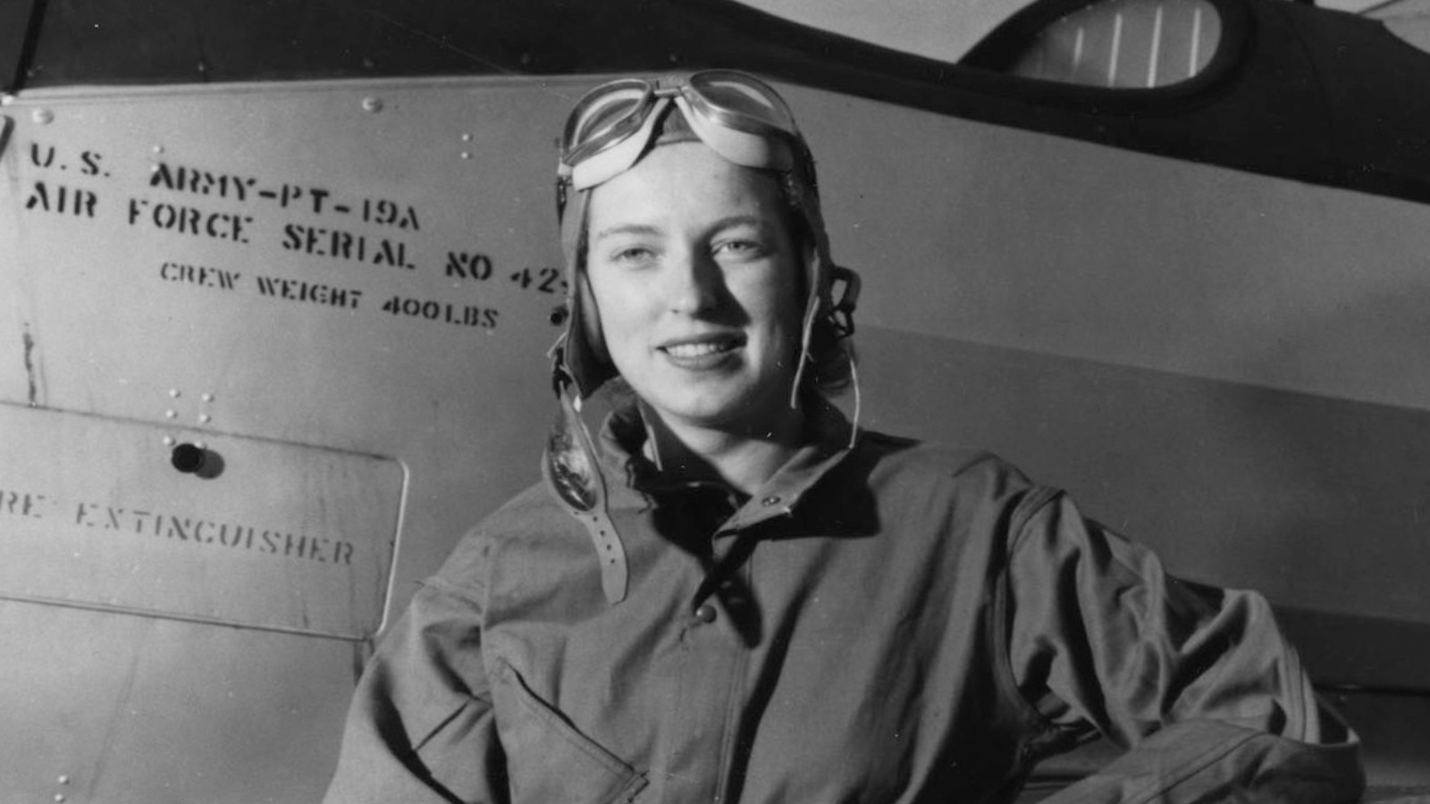 Cornelia Fort avec un PT-19A Cornelia Fort en combinaison de vol à côté d'un avion d'entraînement PT-19A lors de son service au sein de l'escadron auxiliaire féminin de convoyage.