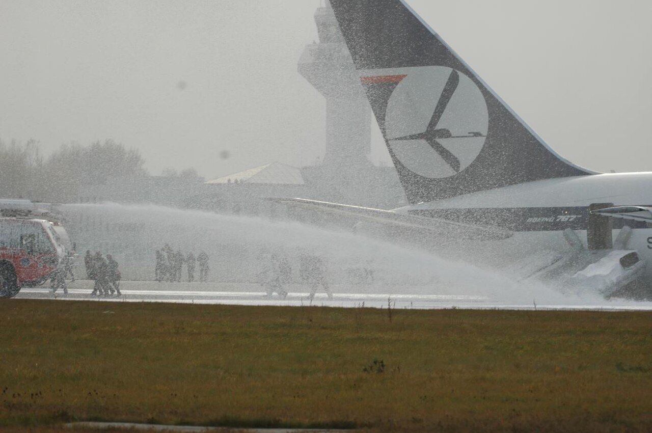 Firefighters foam the LOT Flight 16 fuselage
