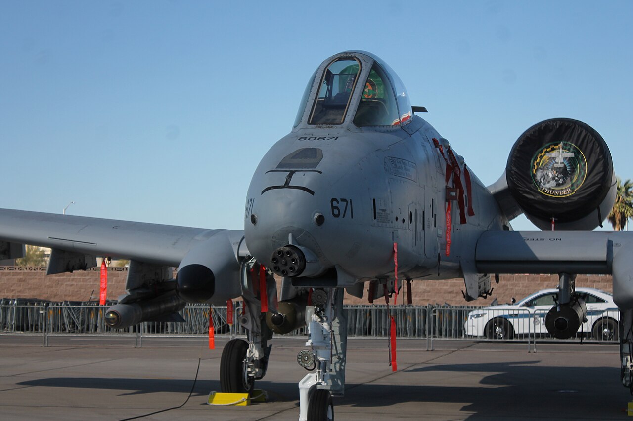 A 66th Weapons Squadron A-10C photographed head-on, the GAU-8 muzzle and squadron badge visible