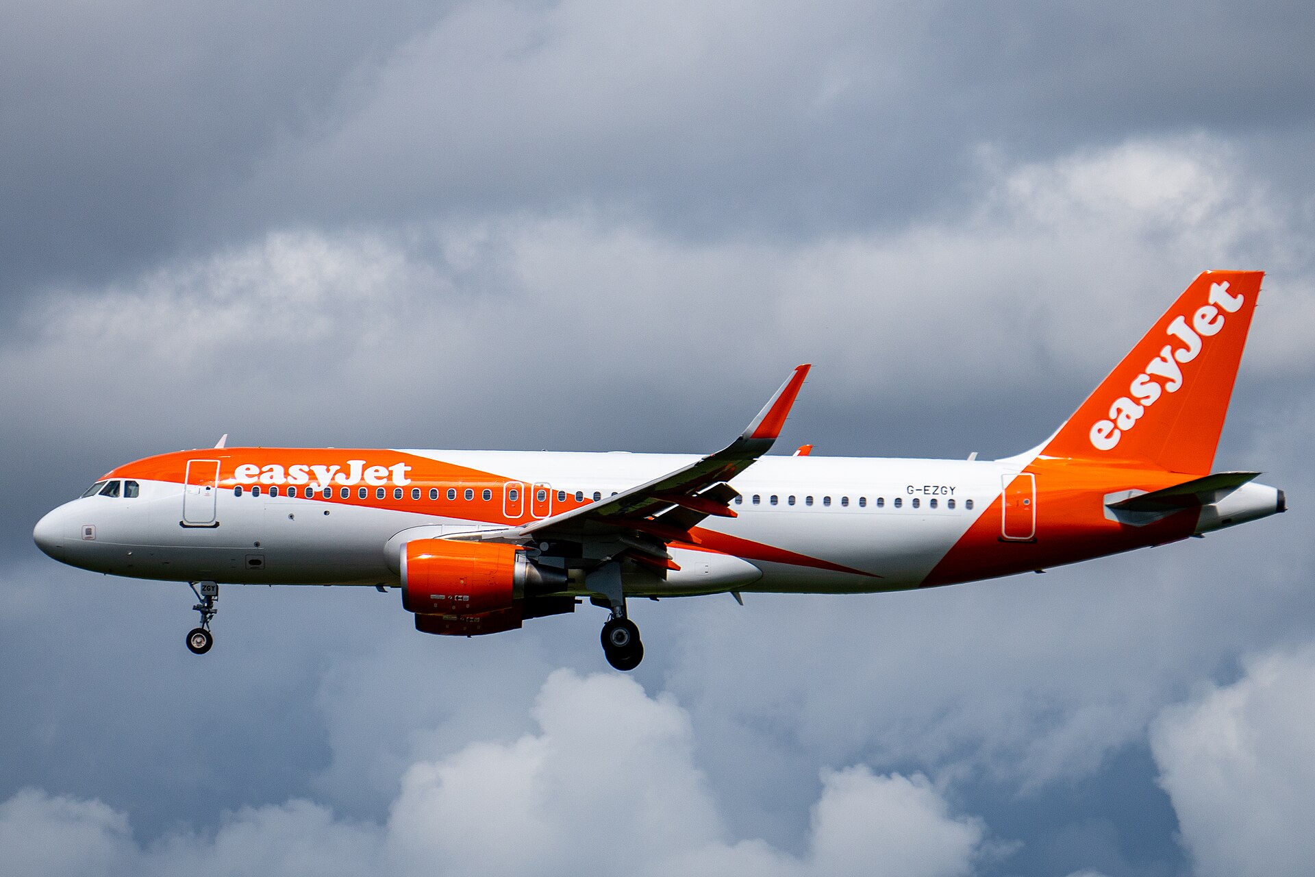 An easyJet Airbus A320 on approach to Edinburgh Airport under grey cloud