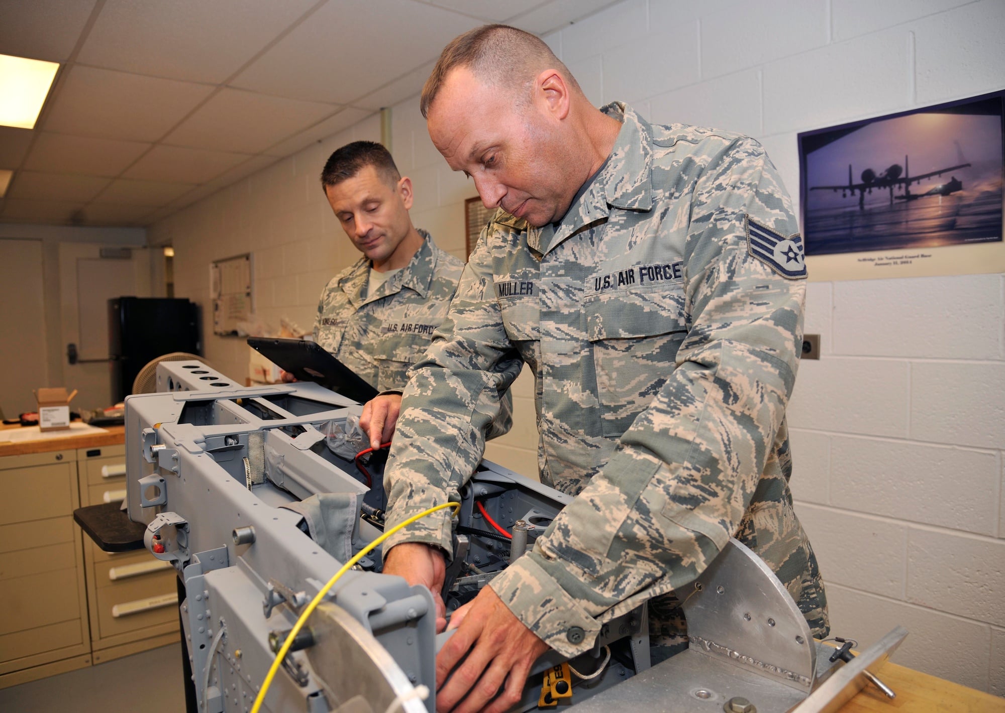 Egress systems technicians work on an ACES II ejection seat