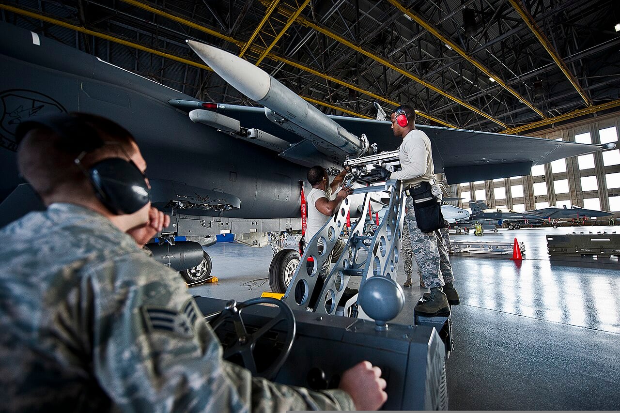 Airmen loading an AIM-120 AMRAAM onto an F-15 Eagle