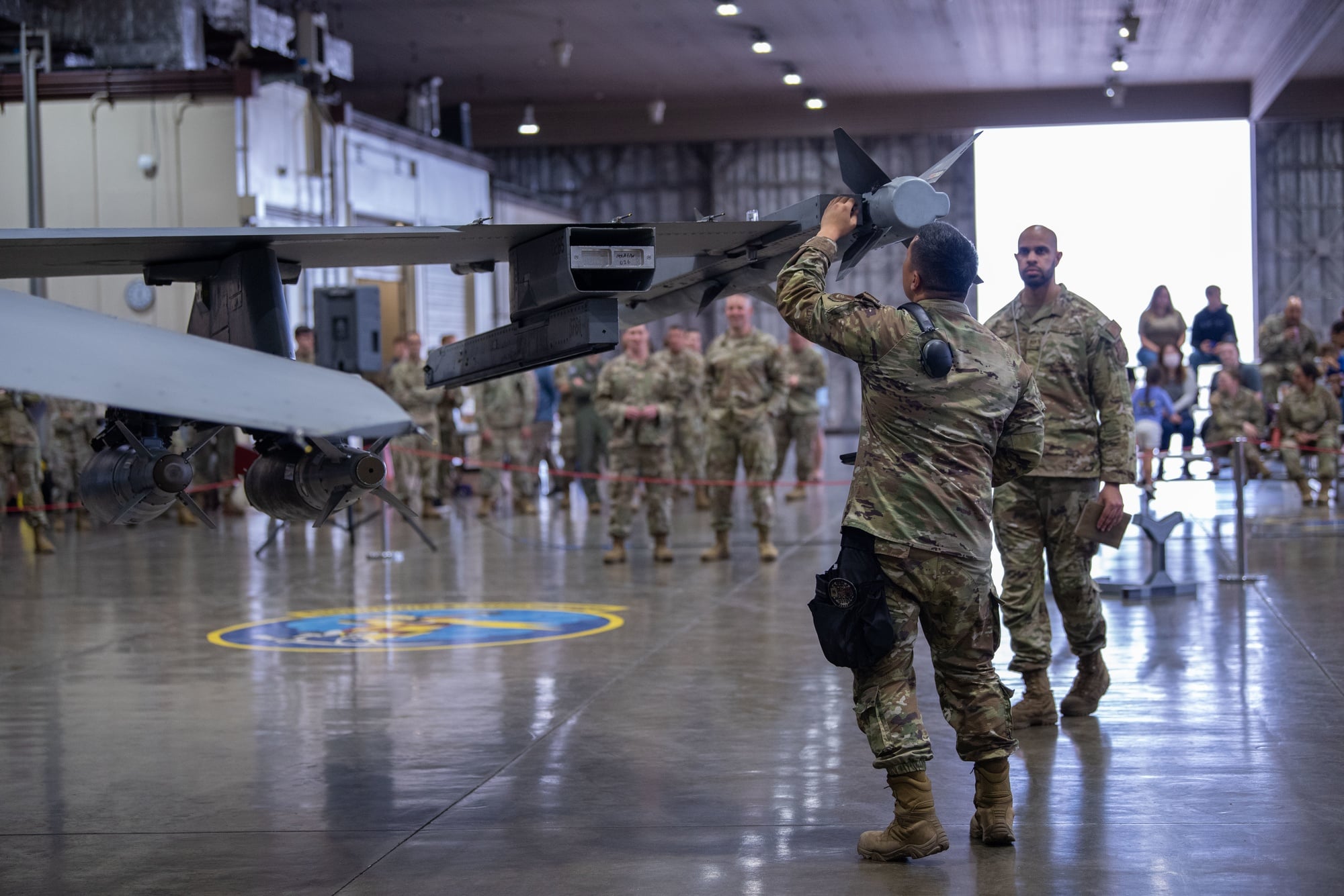 A weapons load crew fitting an inert AIM-9X Sidewinder to an F-16