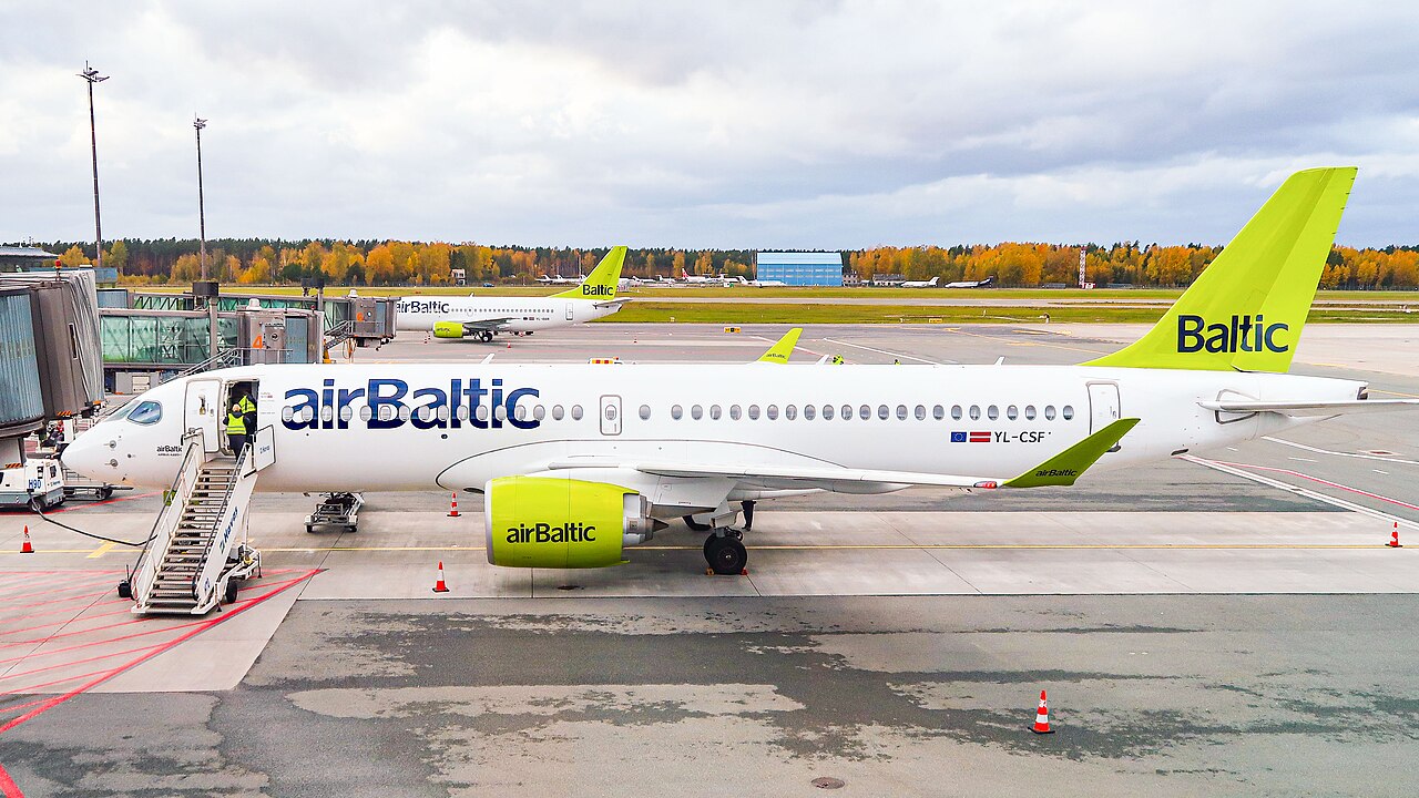 An airBaltic Airbus A220-300 at the gate at Riga Airport