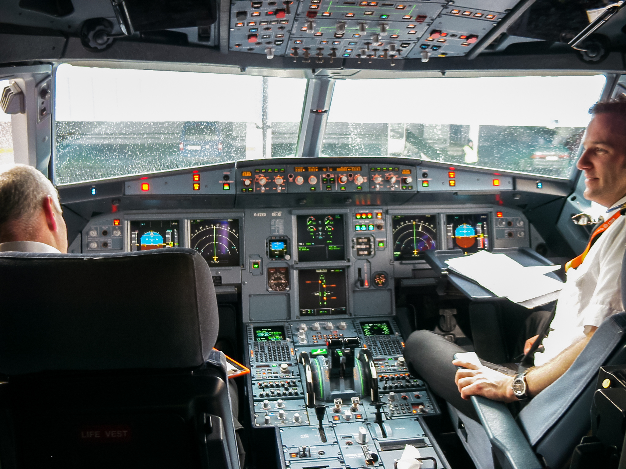Two pilots at work on the flight deck of an Airbus A319