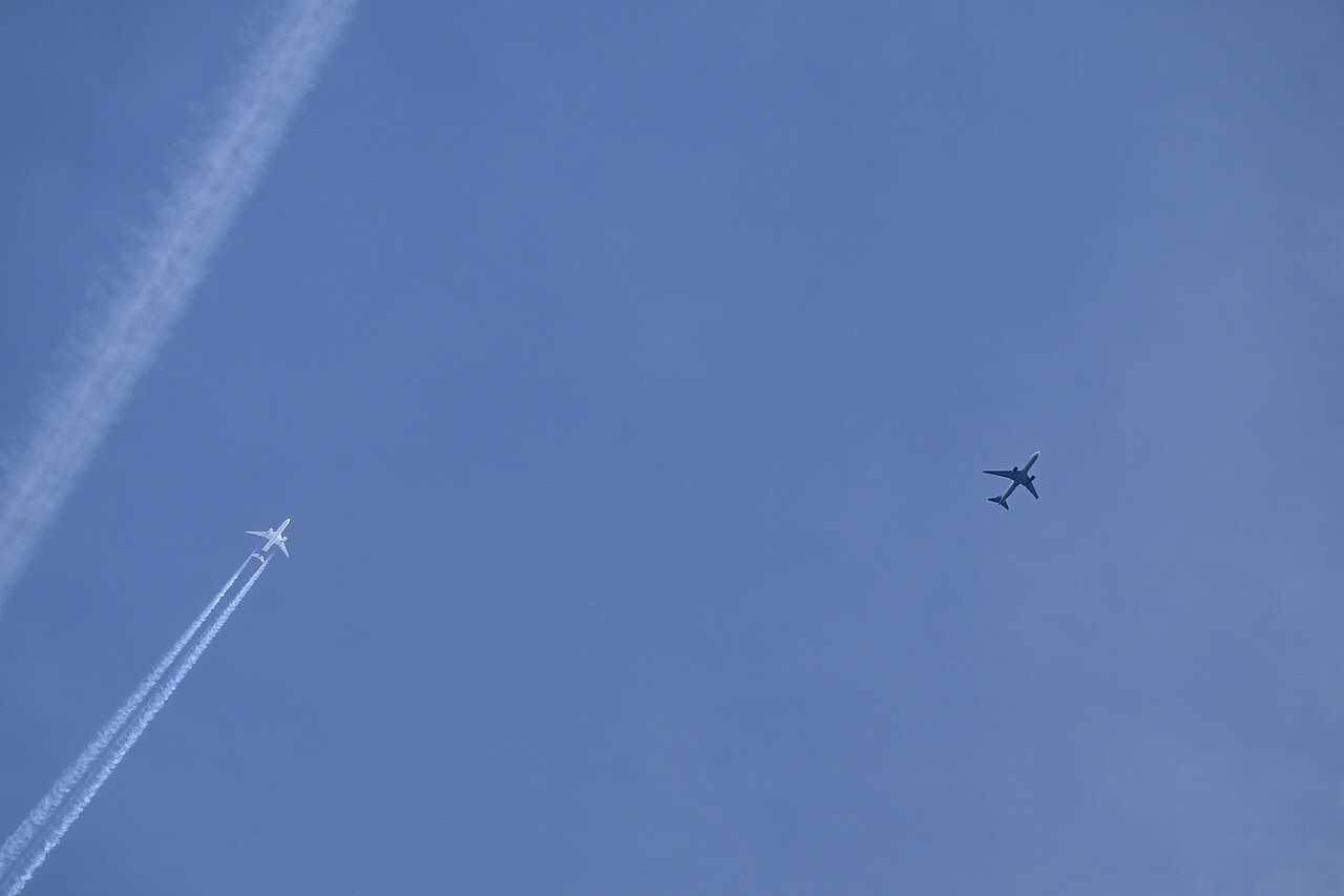 Two airliners at cruise altitude leaving contrails