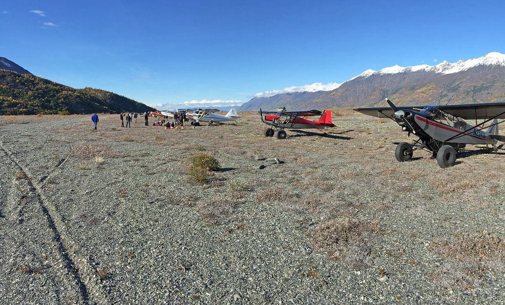 STOL aircraft parked on a gravel bar near the Knik Glacier, Alaska