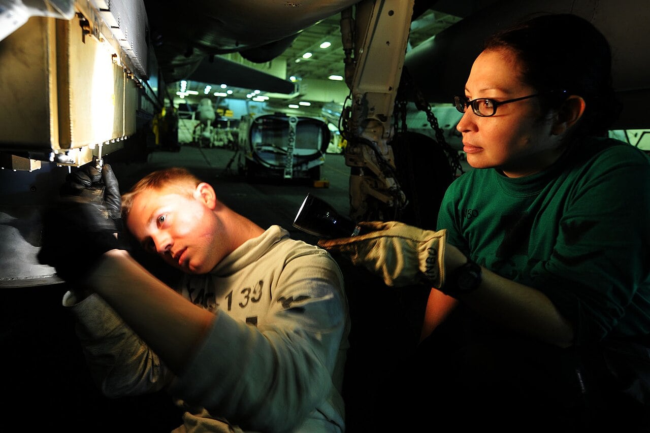 Sailors working on an ALQ-99 jamming pod on an EA-6B Prowler