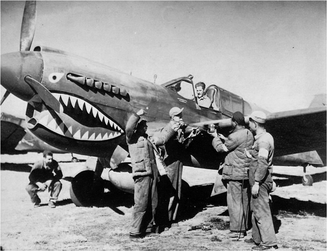 Ground crew and a pilot around an American Volunteer Group P-40 wearing the shark mouth in China