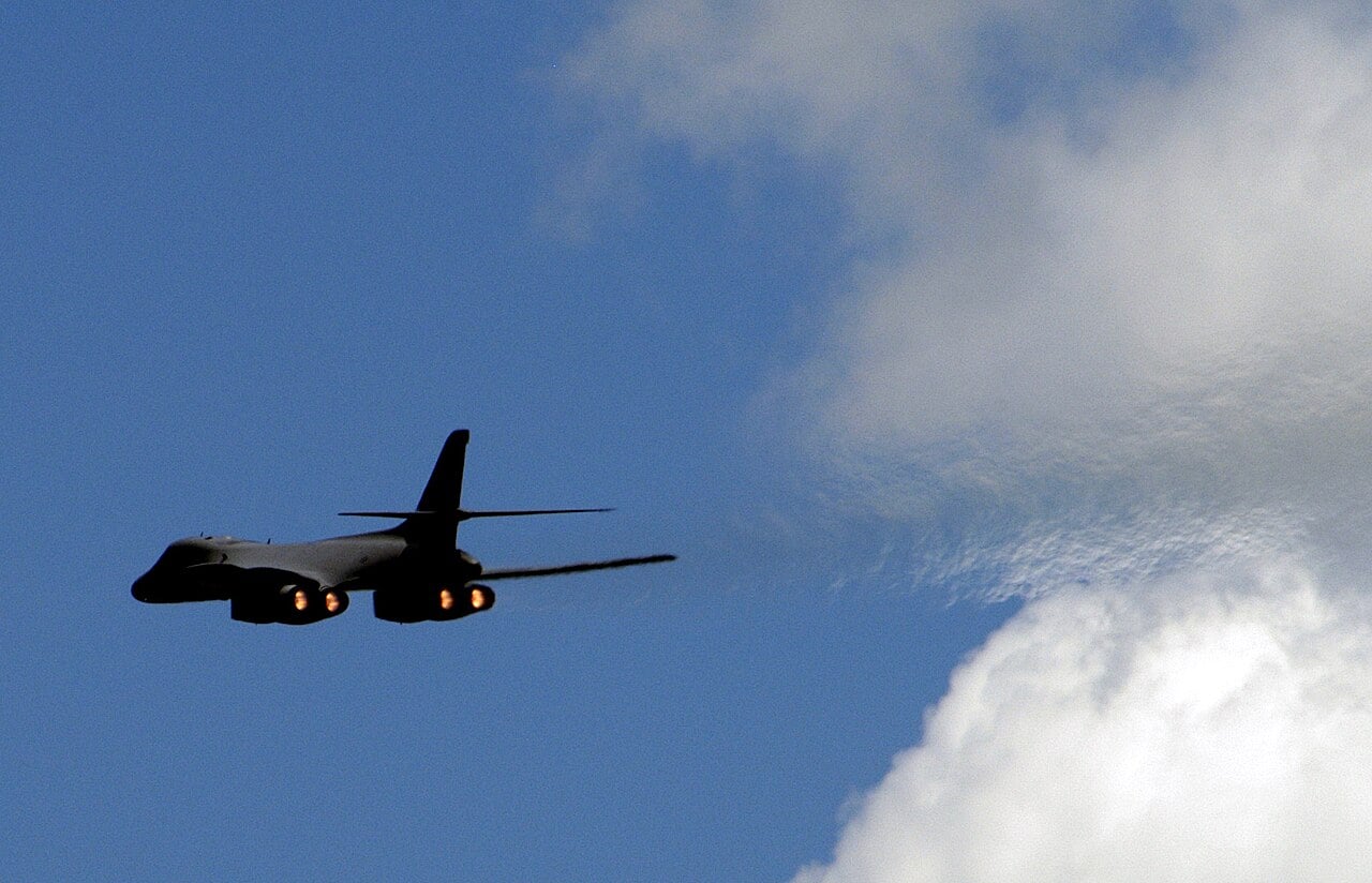 A US Air Force B-1B Lancer bomber making a high-speed pass in full afterburner