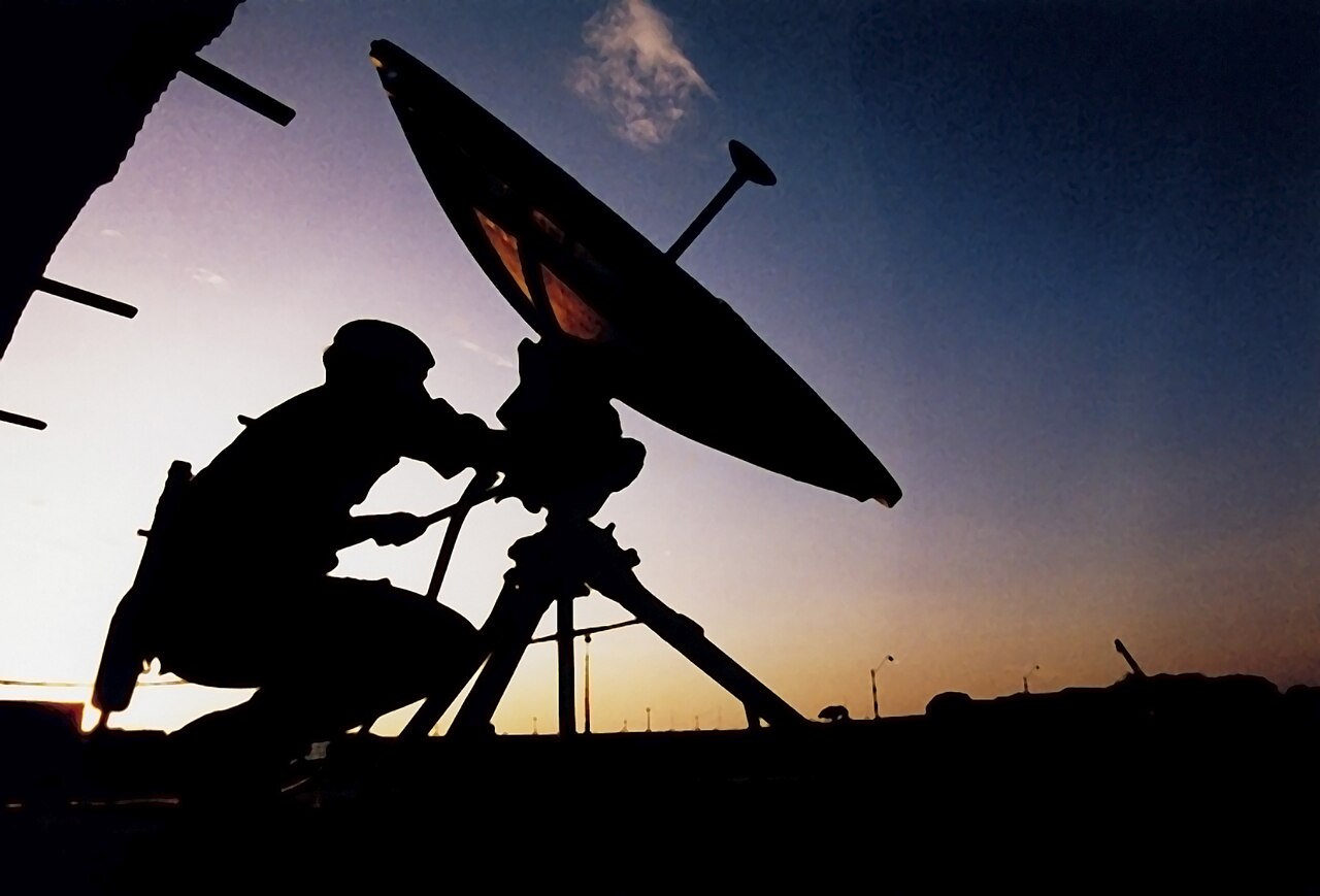 A British soldier adjusting a military satellite communications dish