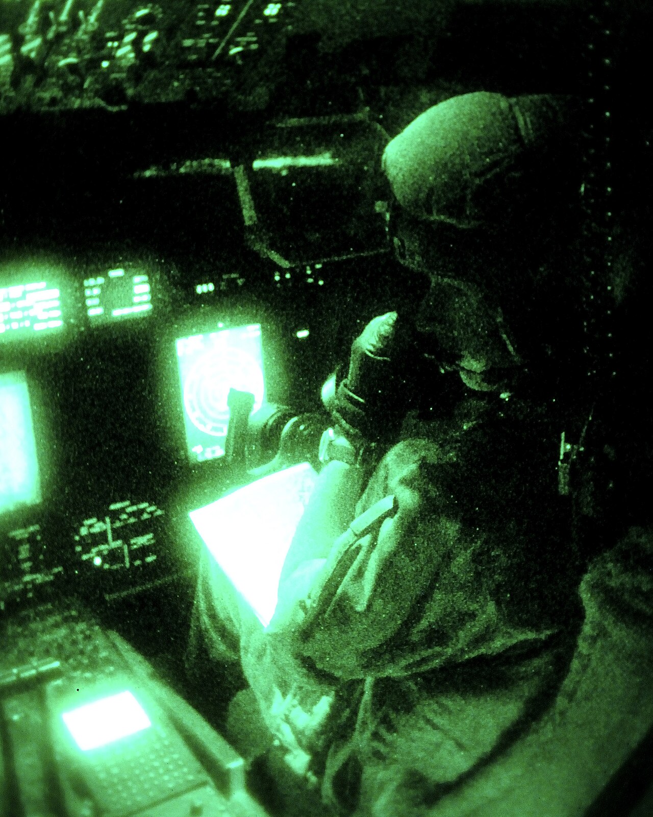 A C-130 Hercules cockpit seen through a night vision image intensifier
