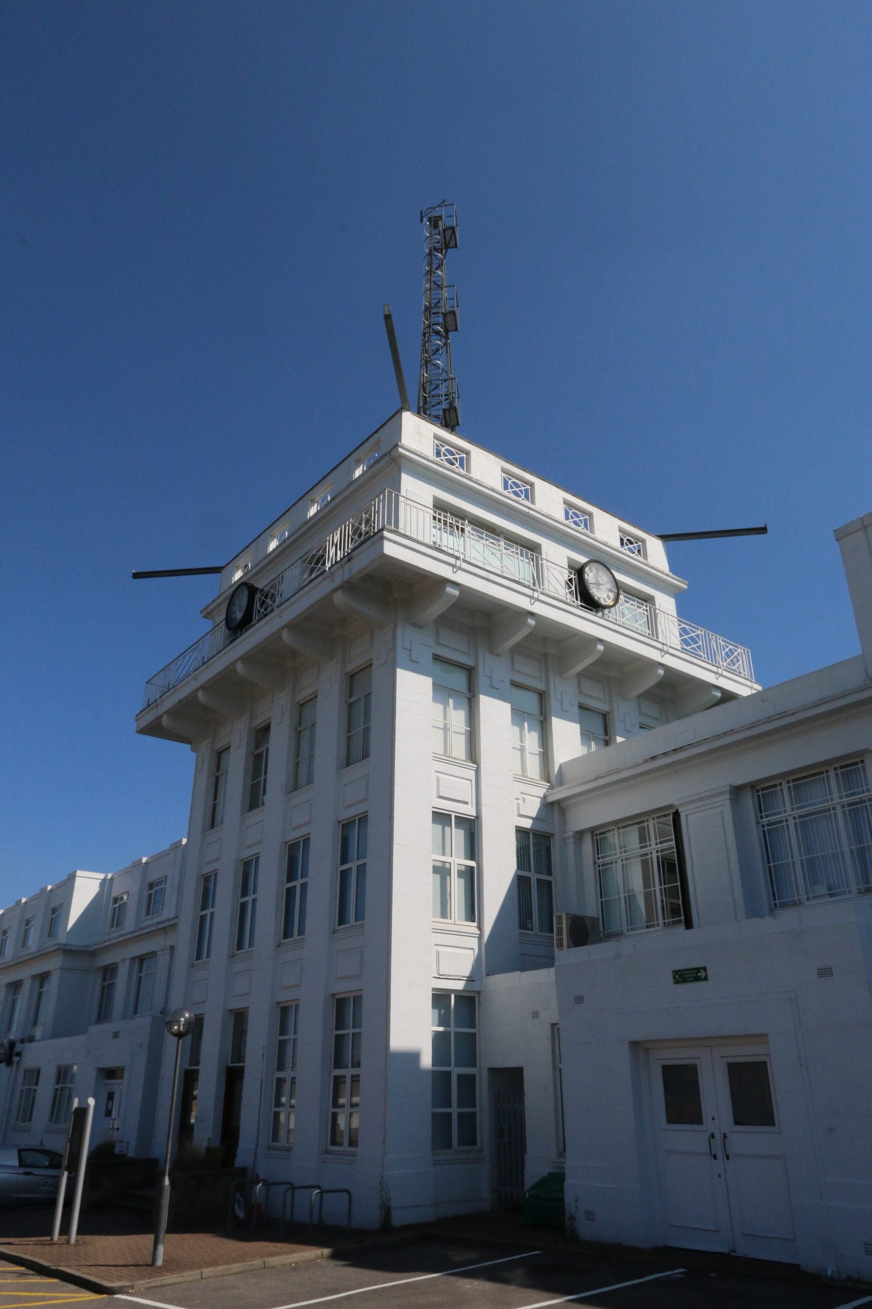 The white Art Deco control tower and terminal building at Croydon Airport with a lattice radio mast on the roof