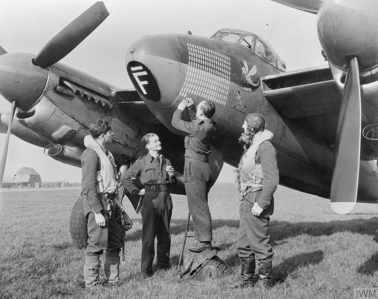 Ground crew marking the operations tally on a No. 105 Squadron Mosquito
