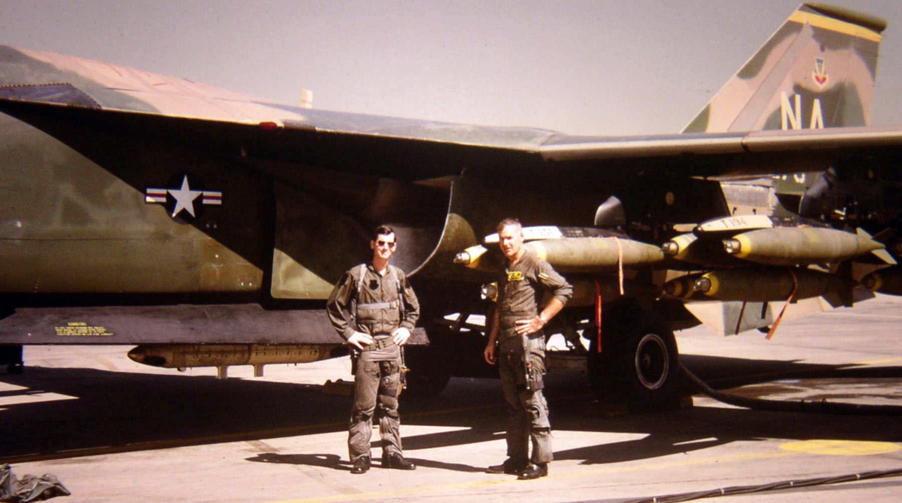 An F-111A crew of the 474th Tactical Fighter Wing standing in front of their bombed-up aircraft at Takhli, Thailand, in 1972