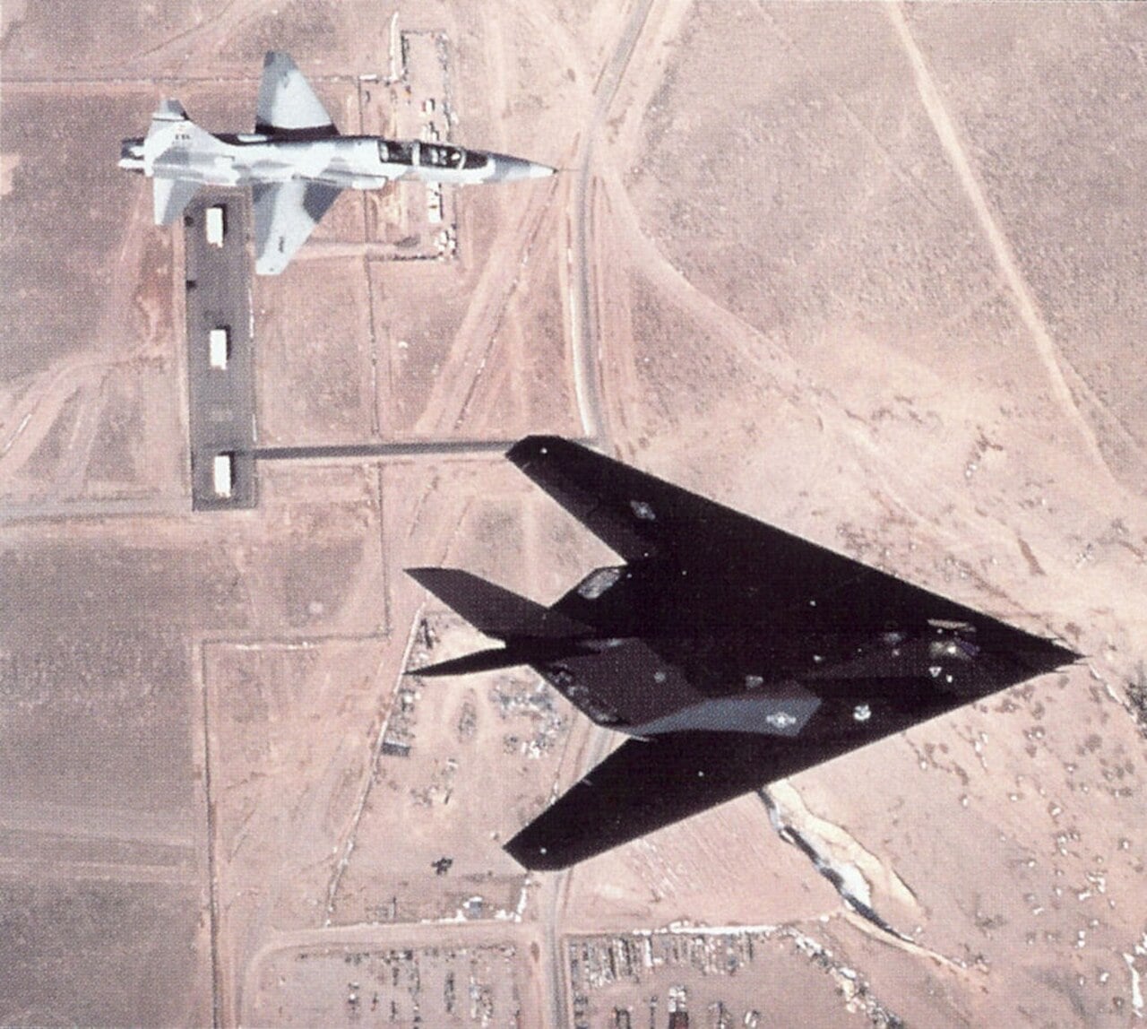 An F-117 Nighthawk and a T-38 Talon flying over Tonopah Test Range Airport