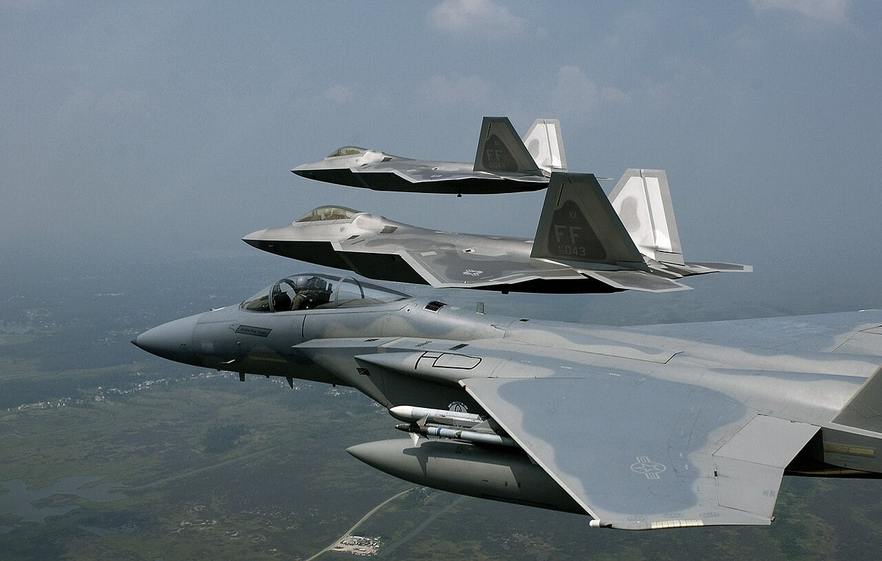 Two F-22 Raptors in formation with an F-15 Eagle