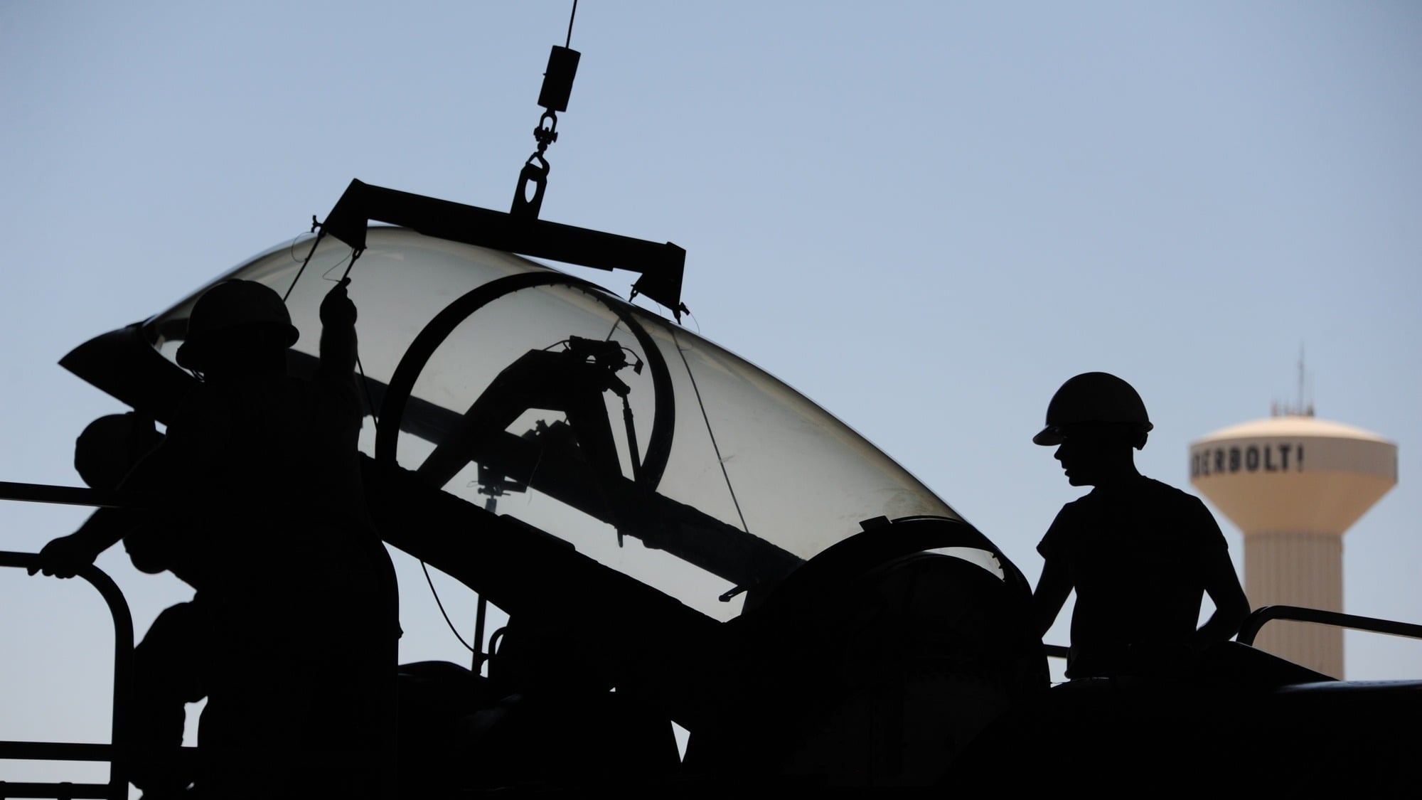 F-16 canopy hoisted by egress systems specialists at Luke AFB Airmen hoist an F-16 canopy at dusk during egress systems maintenance