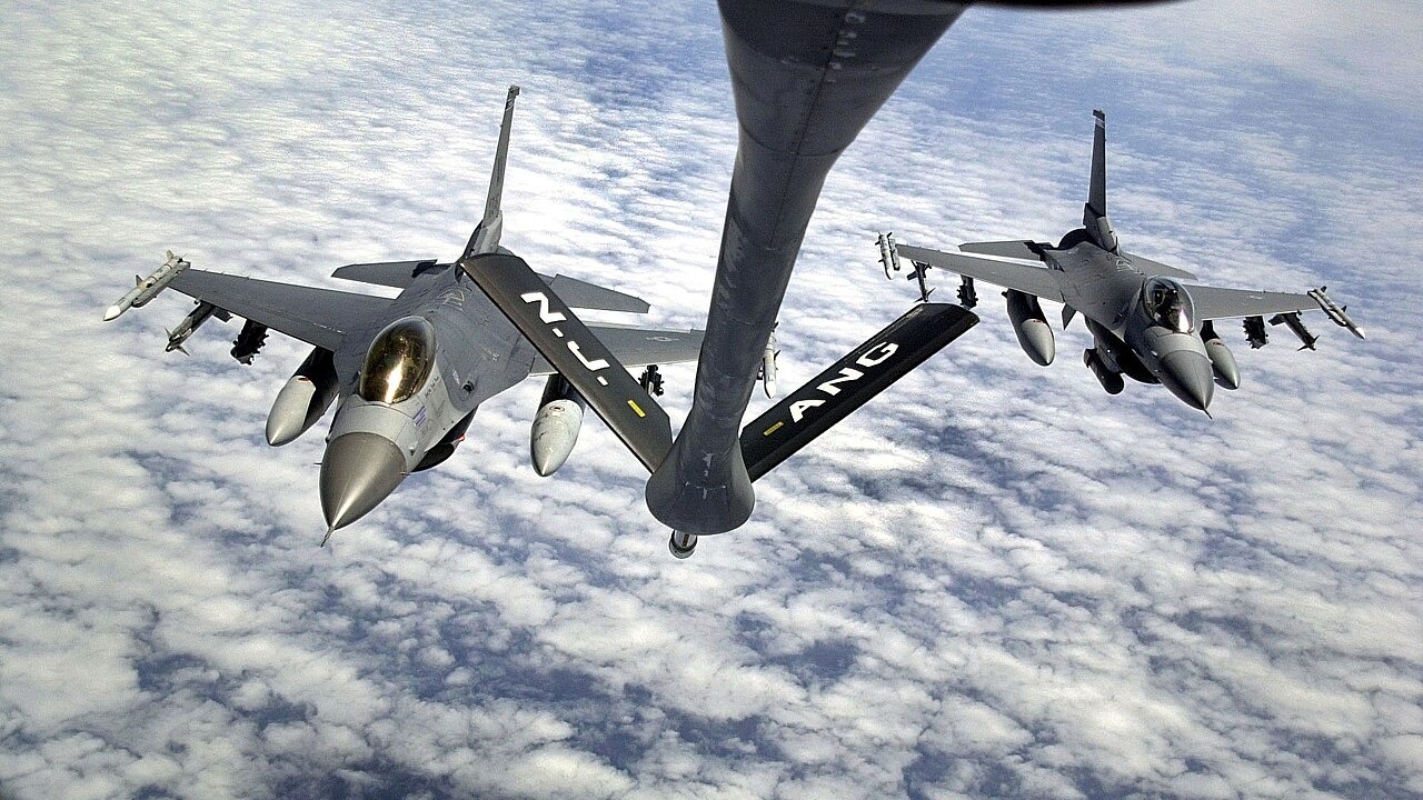 A pair of F-16s dropping away from the refuelling boom of a KC-135 tanker