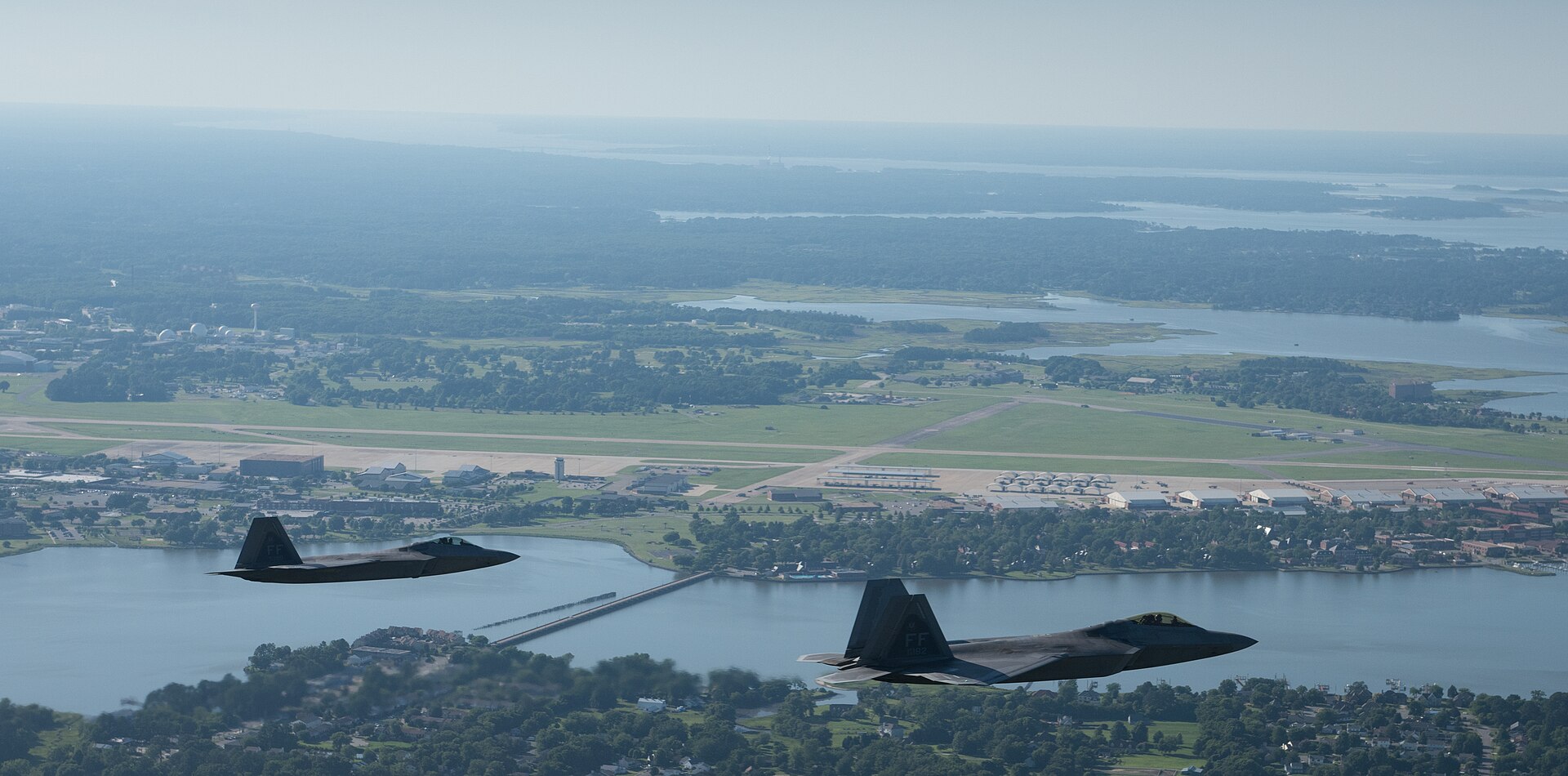 Two US Air Force F-22 Raptors in flight over Joint Base Langley-Eustis, Virginia