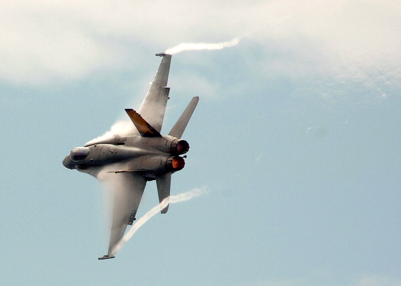 La vapeur révèle les tourbillons au-dessus de l'aile d'un avion de chasse