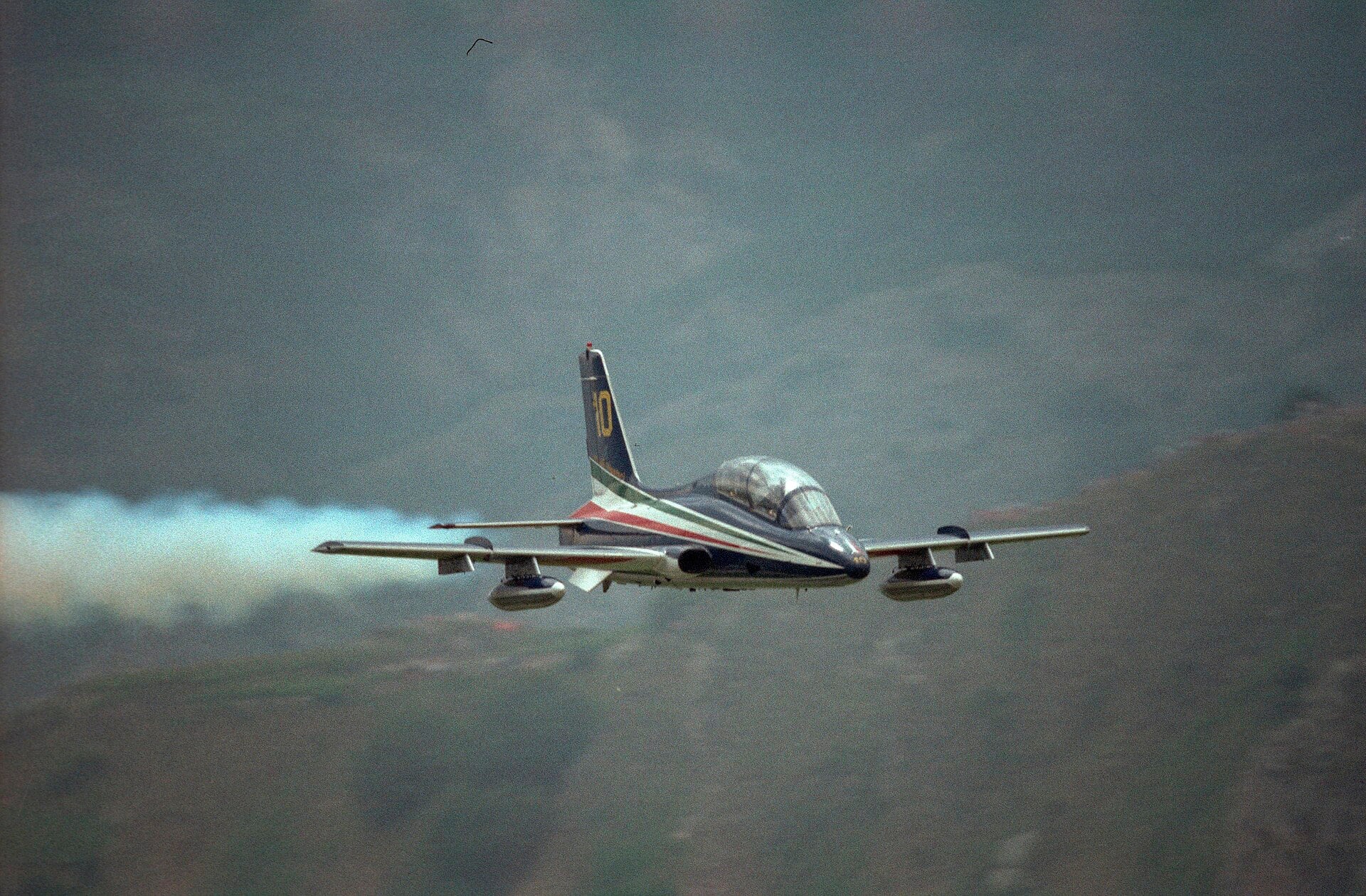 A Frecce Tricolori Aermacchi MB-339 trailing white smoke at low level in 1986