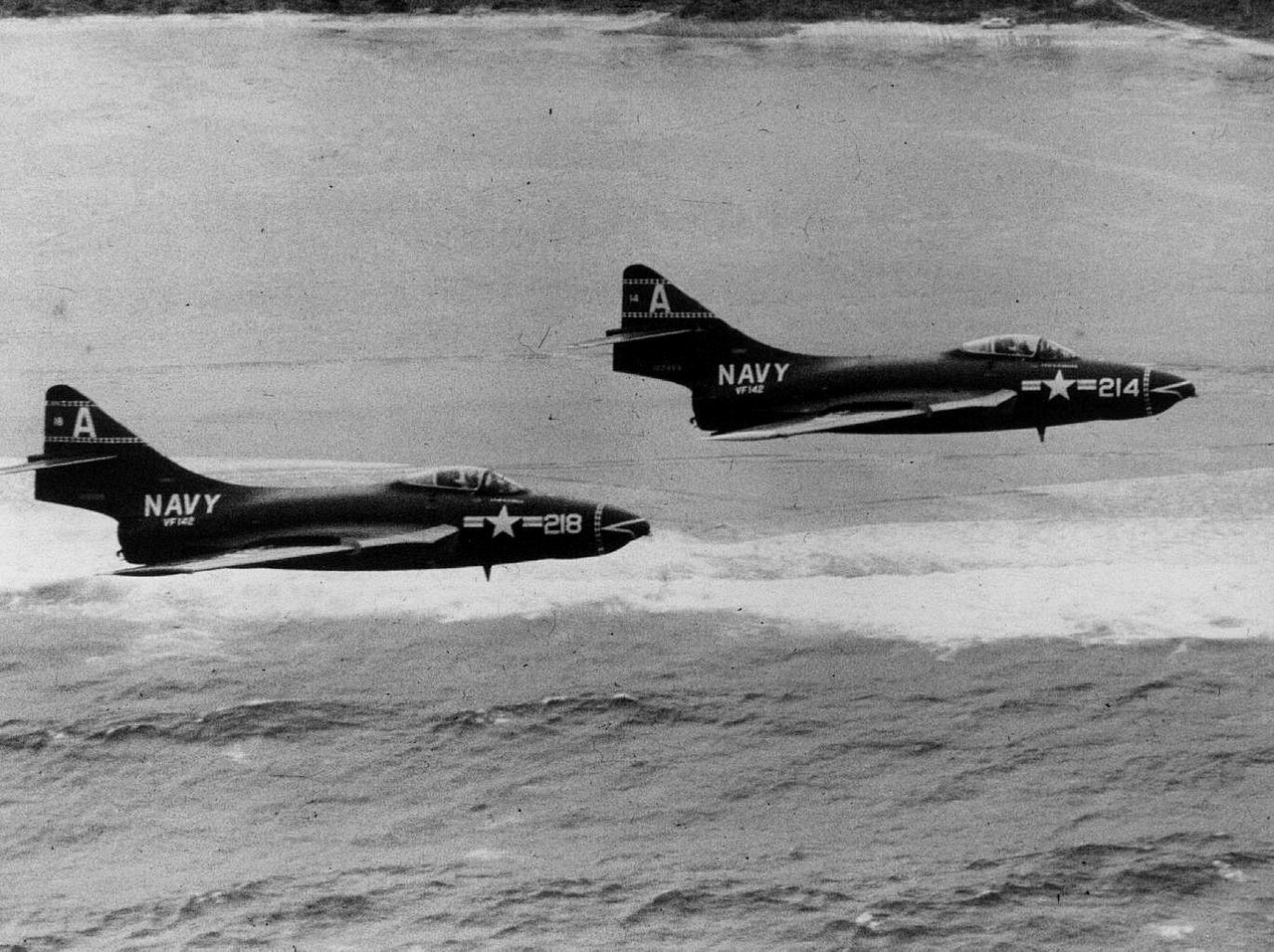 Grumman F9F-6 Cougars of VF-142 in low-level flight, 1956