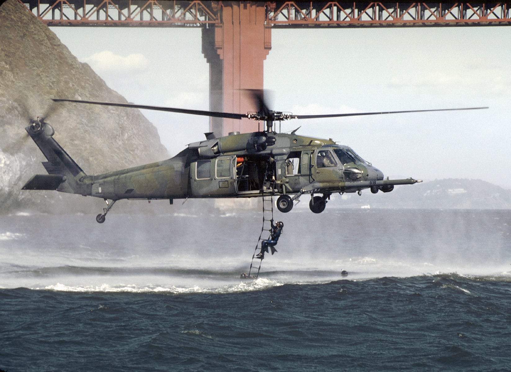 129th Rescue Wing pararescuemen climb a rope ladder to an HH-60 off the Golden Gate 129th Rescue Wing pararescuemen climb a rope ladder to an HH-60 off the Golden Gate