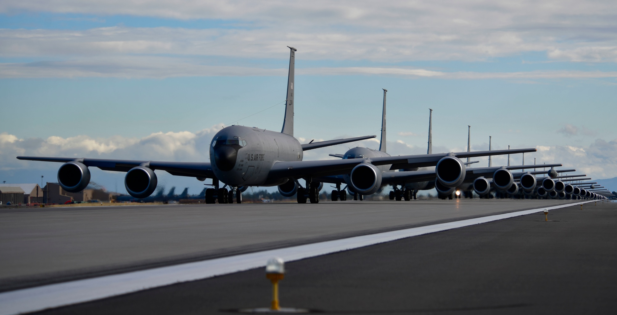 A row of 18 KC-135 Stratotankers lined up on the flightline at Fairchild Air Force Base before a mass launch
