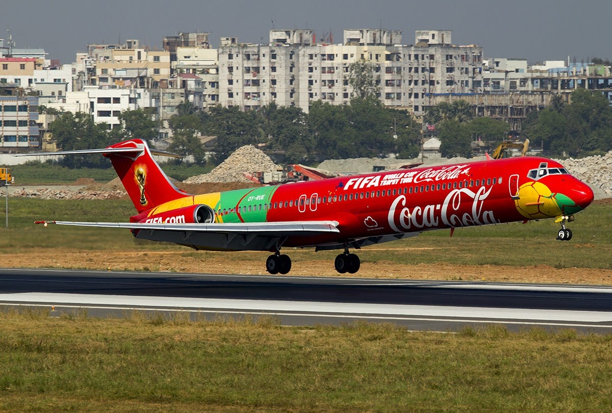 A McDonnell Douglas MD-83 in full red Coca-Cola FIFA World Cup Trophy Tour livery on a runway