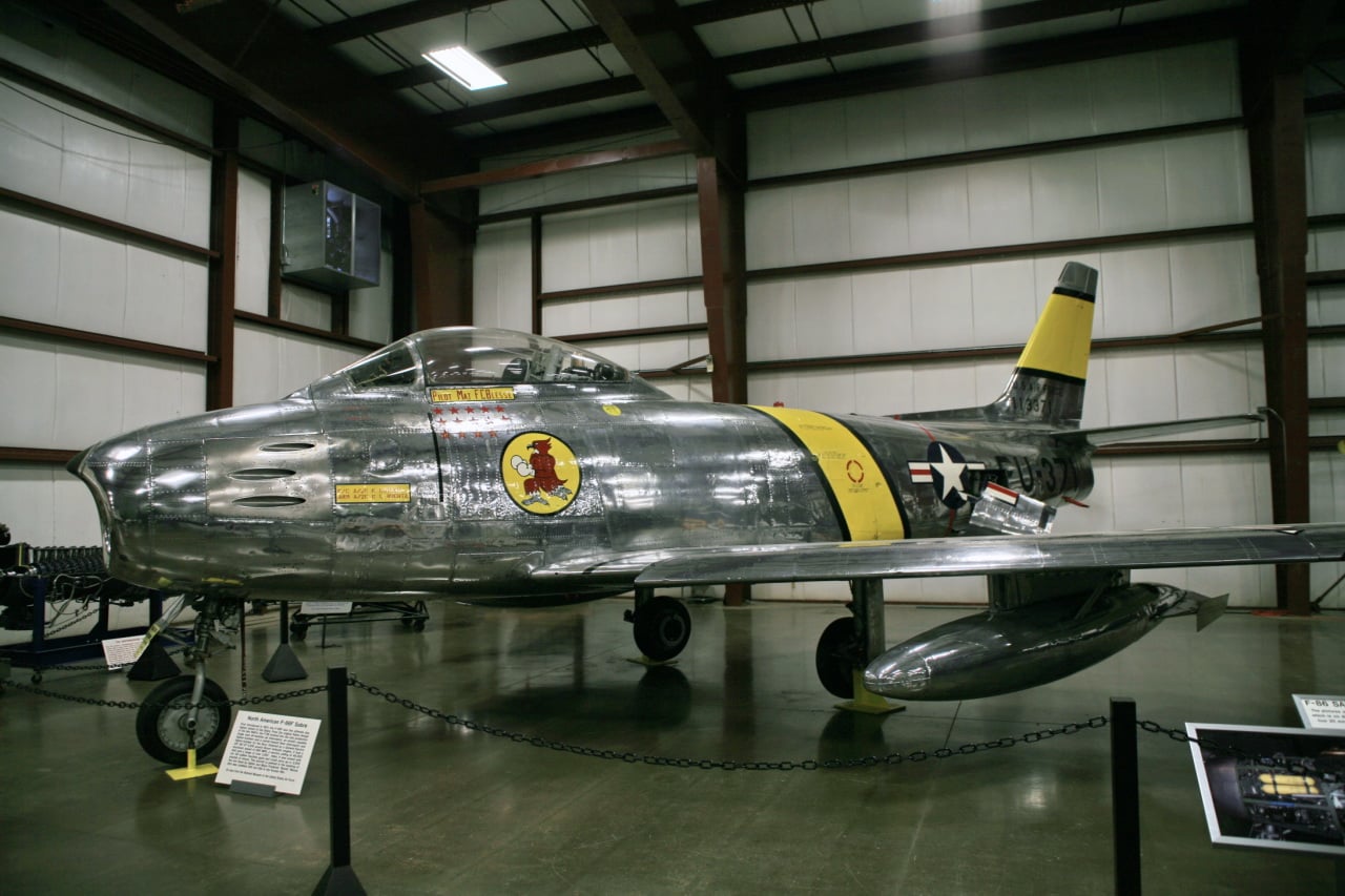 A bare metal North American F-86F Sabre preserved in a museum hangar