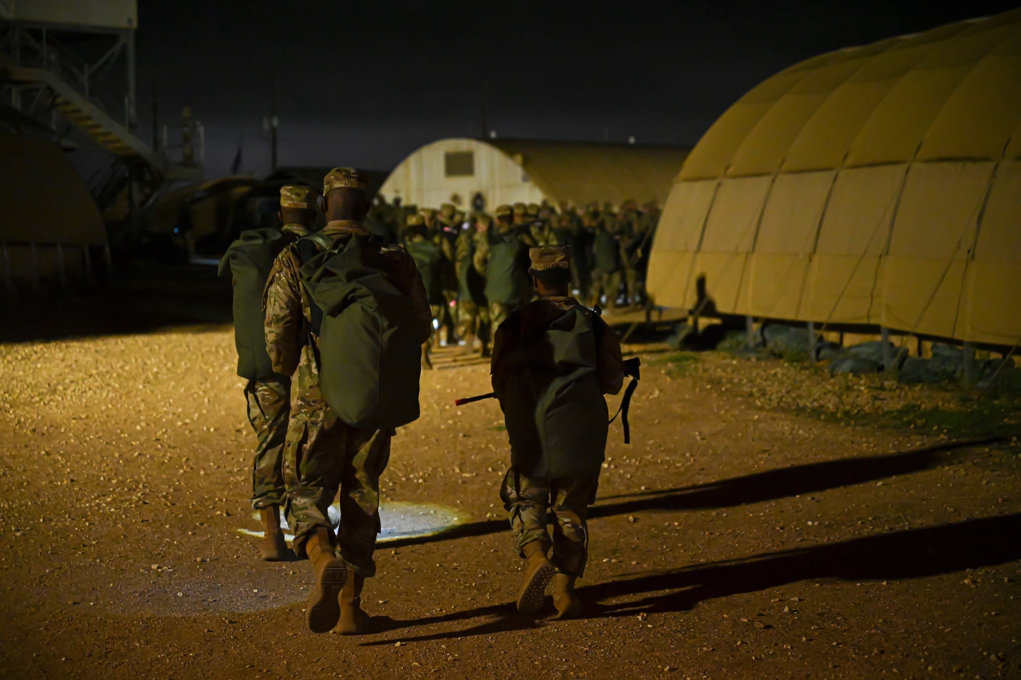 Air Force basic training recruits move through a field exercise at night during PACER FORGE