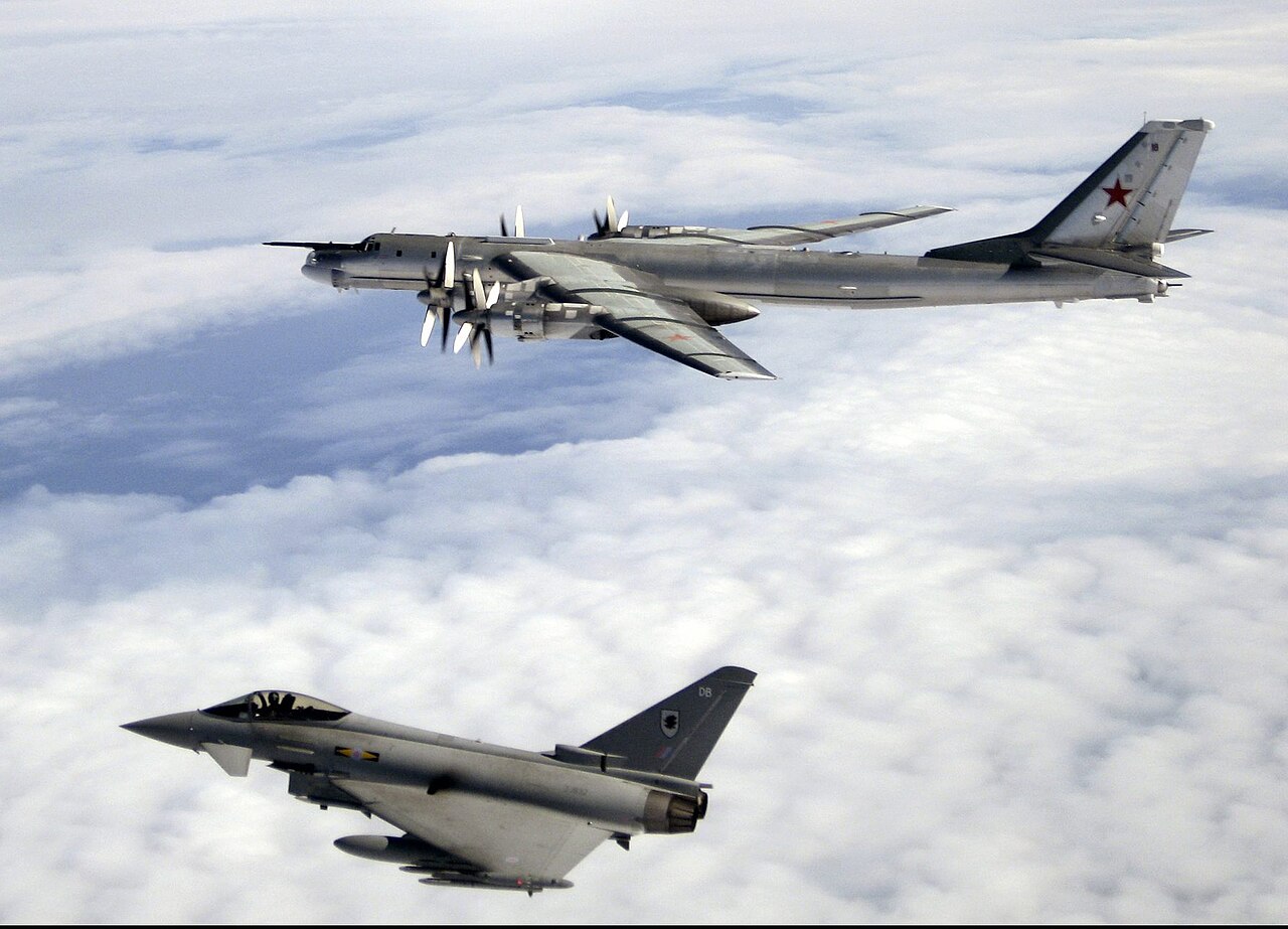 A Russian Tupolev Tu-95 Bear-H bomber flying above cloud with a Royal Air Force Eurofighter Typhoon alongside