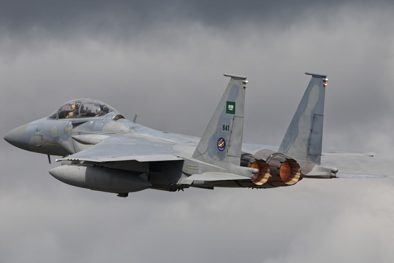 A two-seat Royal Saudi Air Force F-15SA Eagle in RSAF markings with afterburners lit