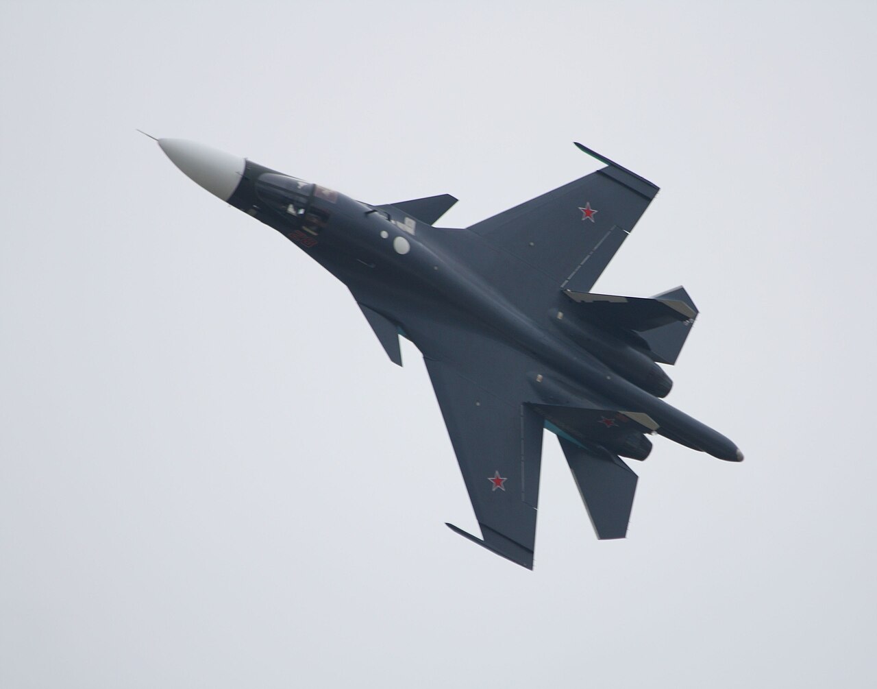 A Sukhoi Su-34 Fullback fighter-bomber on display, showing its distinctive flattened nose and side-by-side cockpit