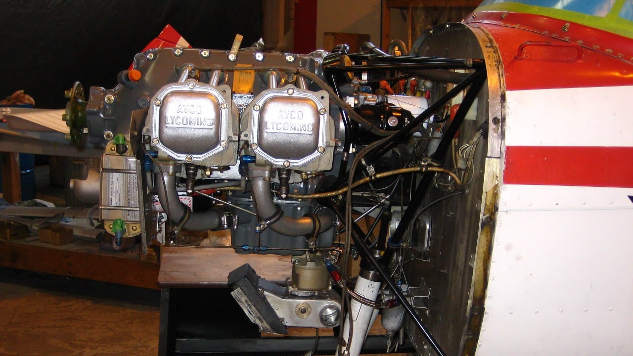 A Cessna 152 Lycoming engine with the cowlings removed, exposing cylinders, plugs, hoses and filters