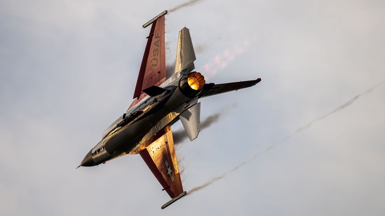 US Air Force F-16 Viper Demonstration Team jet banked hard in a high-G turn with its afterburner lit