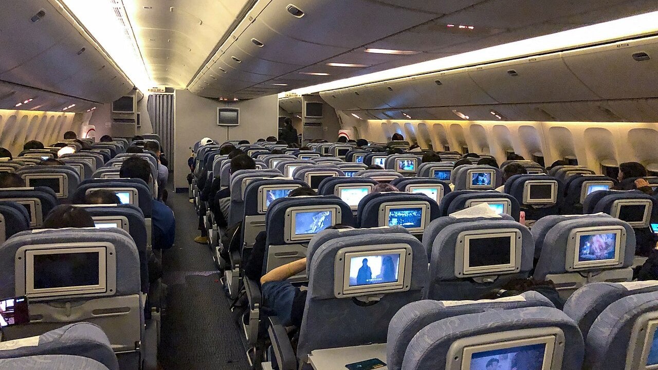 How airlines price tickets: one cabin, many fares Passengers in a full airline economy cabin, where seats are sold at many different fares