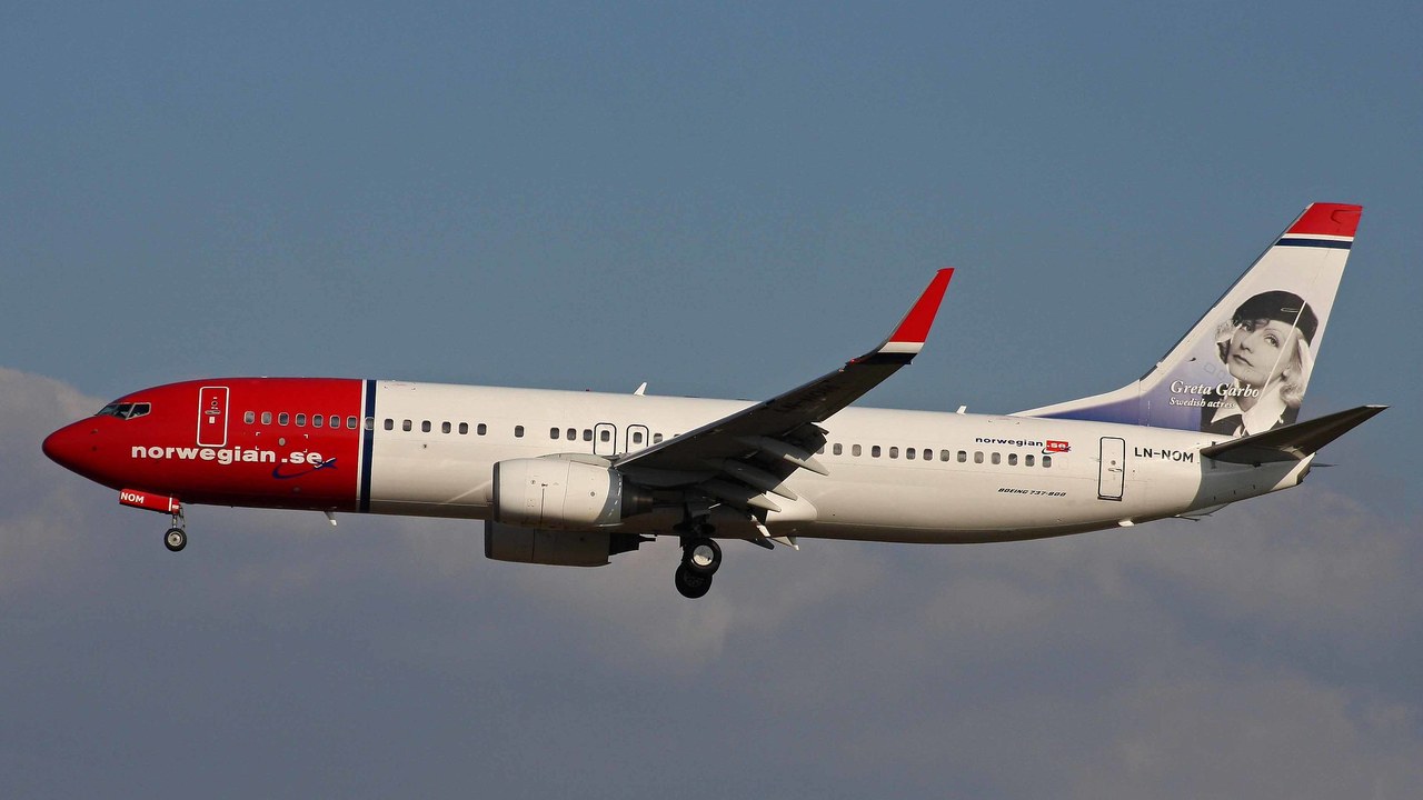 Norwegian Air Shuttle Boeing 737-800 LN-NOM with a portrait of Greta Garbo on its tail fin, gear down on approach